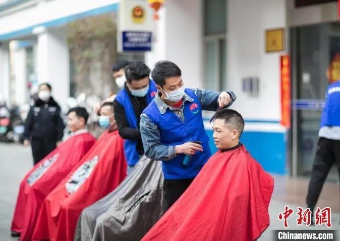义工为派出所民警和辅警理发。　陈选平 摄