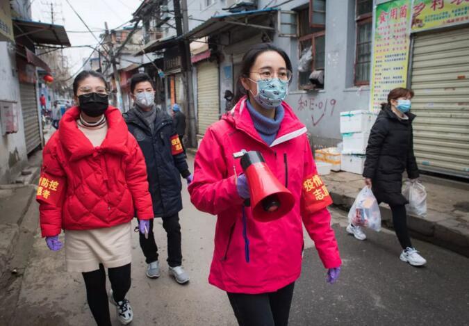 2月7日，中华路街道西城壕社区党委书记翁文静(右二)与志愿者柳莹(左一)、张琦(左二)上街进行防疫宣讲。新华社记者肖艺九摄

