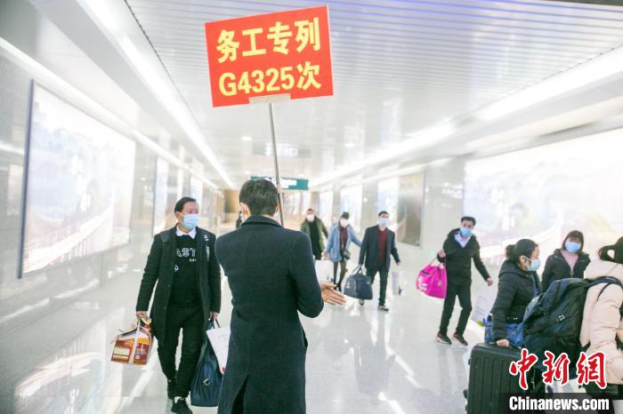 2月20日，在贵州省毕节市大方站，工作人员正在引导返岗农民工走乘车相应通道。　罗大富 摄