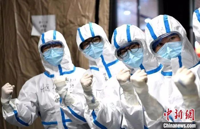 图为武汉医护人员在进入病区前加油鼓劲。安源 摄