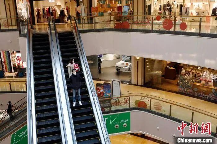 　资料图：上海市民戴着口罩在吴江路休闲街上的商场内逛街。 殷立勤 摄