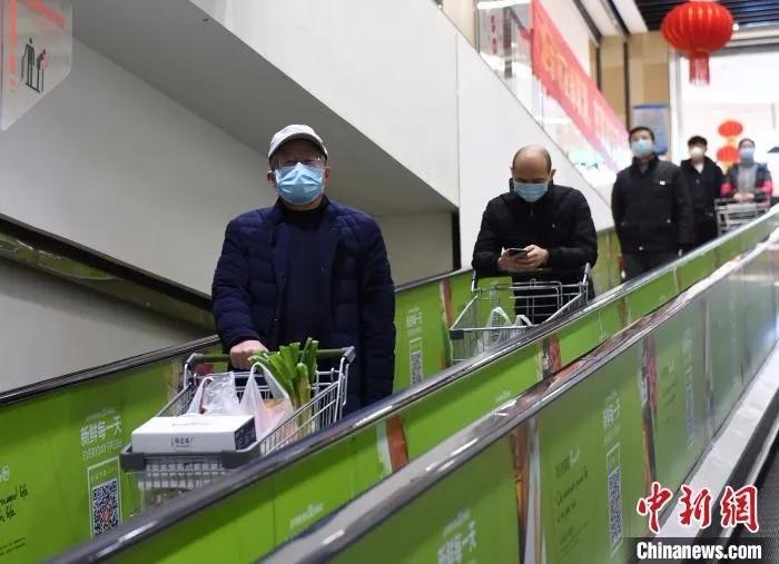 资料图：市民戴着口罩逛超市。　周毅 摄
