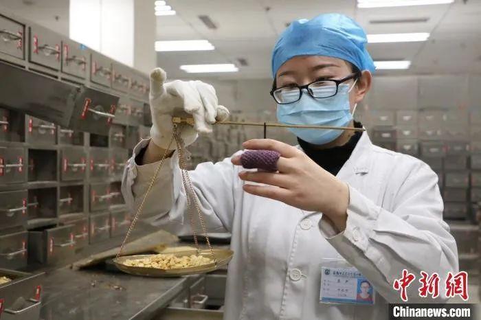 中药师正在称量药材。　夏莹　摄