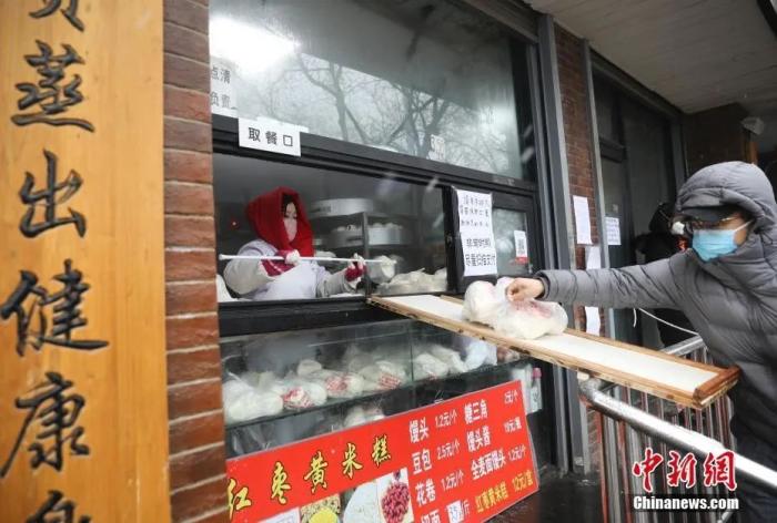 2月14日，一位顾客通过滑板买馒头。中新社记者 赵隽 摄