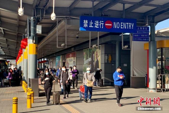 1月30日下午，有不少香港市民经由深圳湾口岸返回香港，而大人小孩均戴上口罩乘坐跨境直通巴士过境。中新社记者 李志华 摄