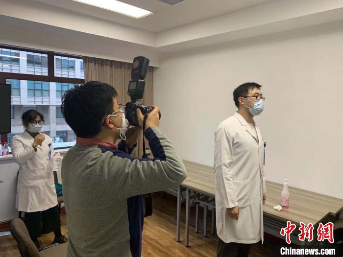 图为媒体记者记录张晟剪发前的模样。　张斌 摄