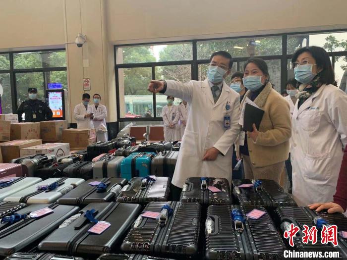 即将带队前往武汉的浙大一院院长、党委副书记黄河(左1)正在指导集结随队物资。　张斌 摄