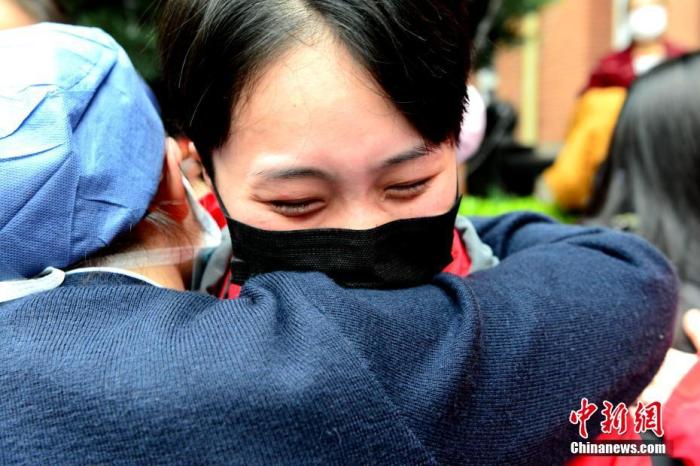 图为出征的医护人员(右)与同事拥抱。中新社记者 王东明 摄