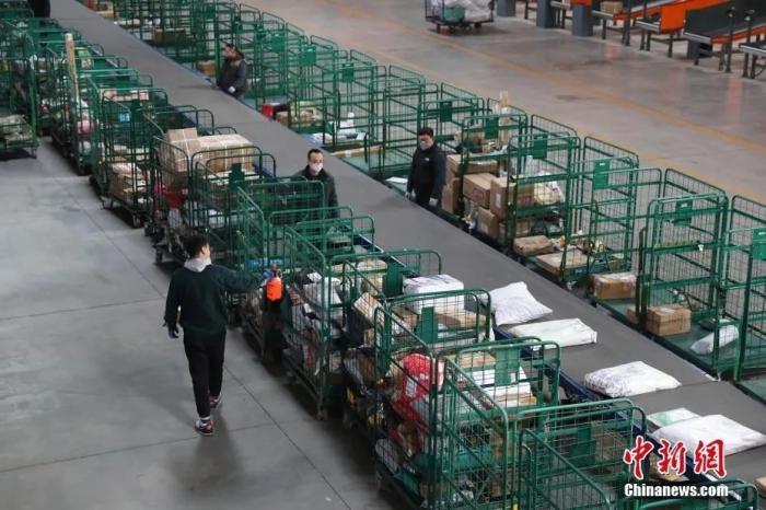 资料图：2月20日，宁夏银川邮政分拣中心的员工在对邮件进行消毒。宁夏多家快递公司已陆续恢复到正常运营模式。中新社记者 于晶 摄