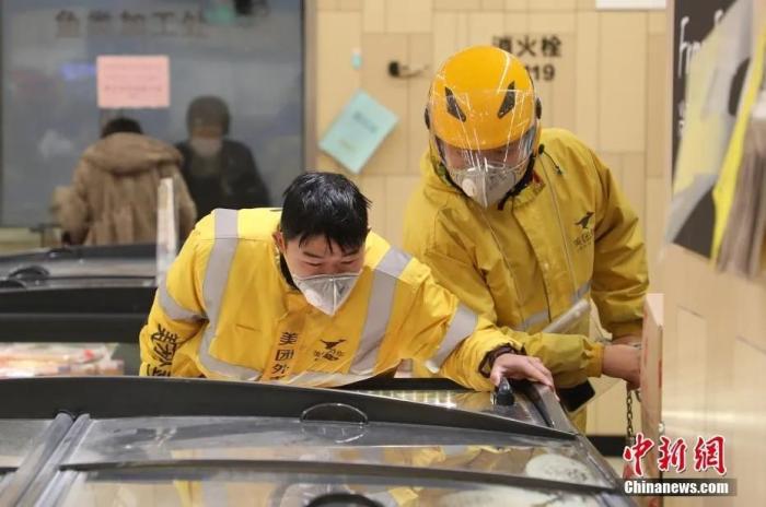 资料图：2月7日，浙江杭州，两位外卖派送人员戴着口罩在超市取货。中新社记者 王伟臣 摄