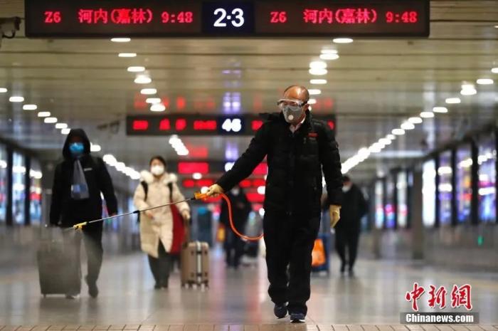 　资料图：工作人员在北京西站出站口进行消毒工作。中新社记者 富田 摄