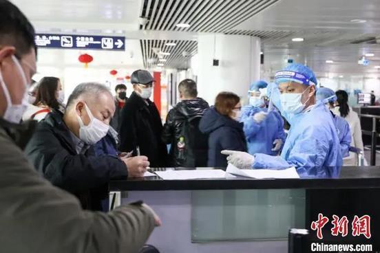 资料图：青岛流亭机场海关关员指导旅客填写健康申明卡。解豪 摄