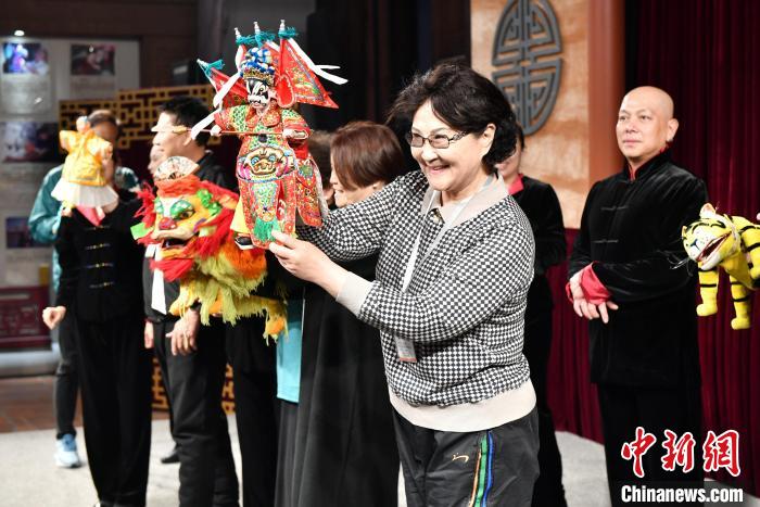海外华文媒体代表陈薇(前)体验布袋木偶操作。　　吕明 摄