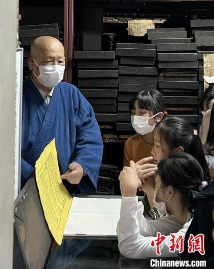 黄檗宗法师向日本华人亲子研学团孩子讲解印刷、稿纸等黄檗文化内容。　张艳 摄